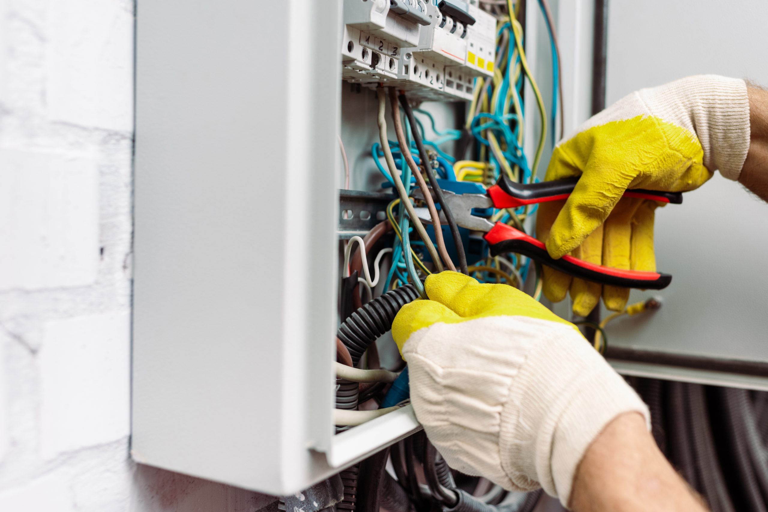 Electricista revisando el cableado existente de un cuadro eléctrico
